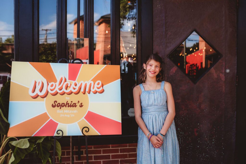 Bat Mitzvah Girl at her custom welcome sign made by event planner